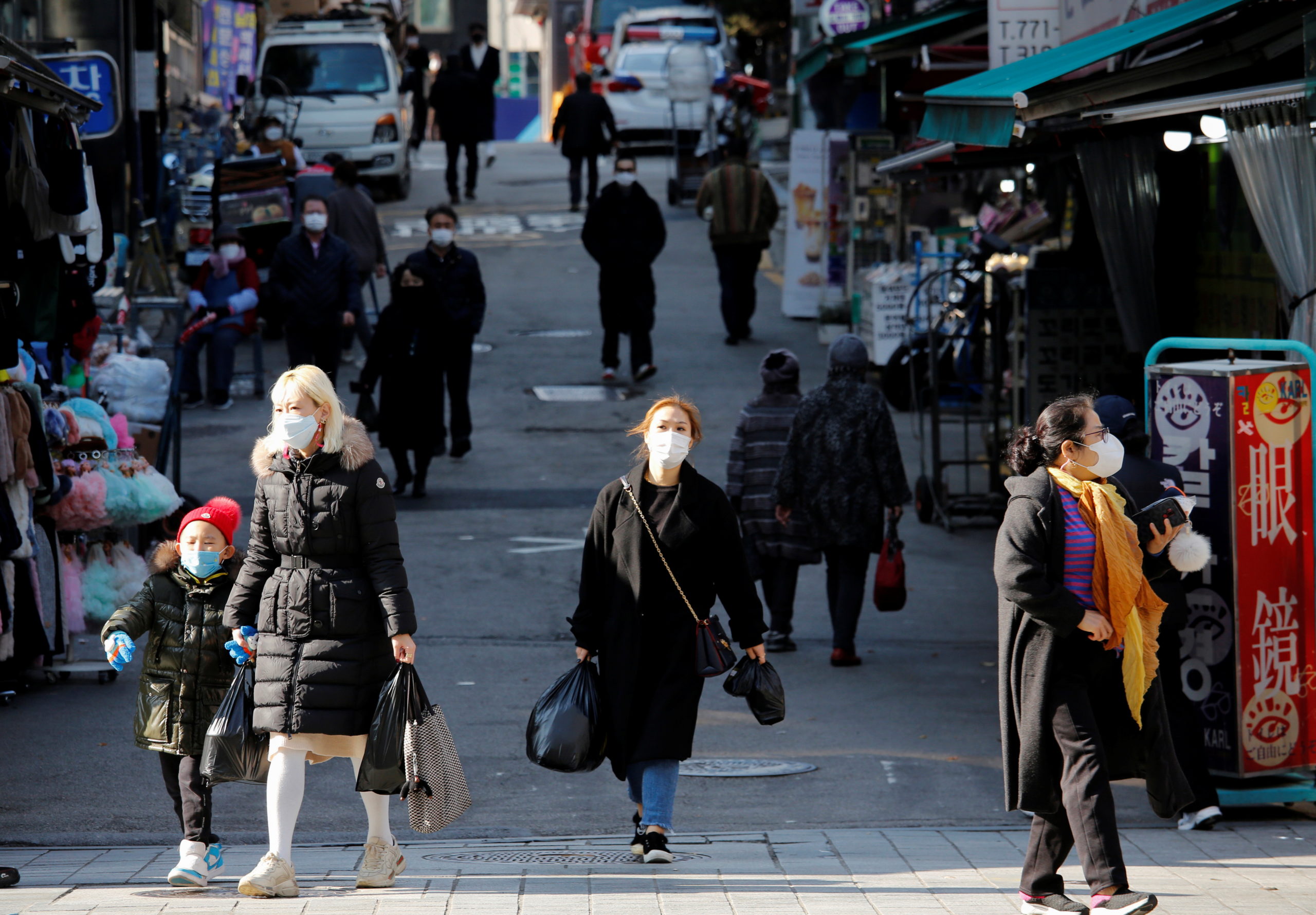 FILE PHOTO: People wearing face masks walk?at a traditional market amid the coronavirus disease (COVID-19) pandemic in Seoul, South Korea, November 27, 2020.   REUTERS/Heo Ran