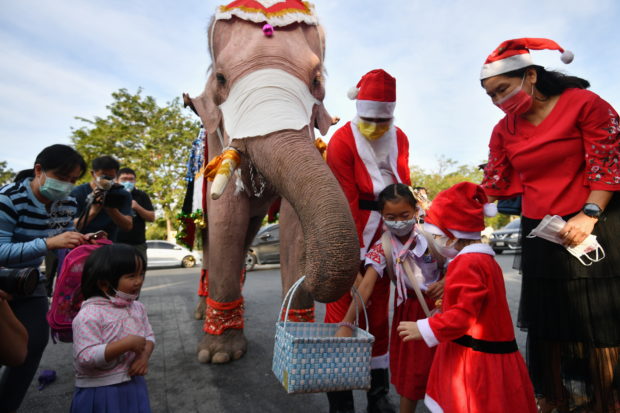 Santa rides elephants to Thai town, bearing gifts of face masks