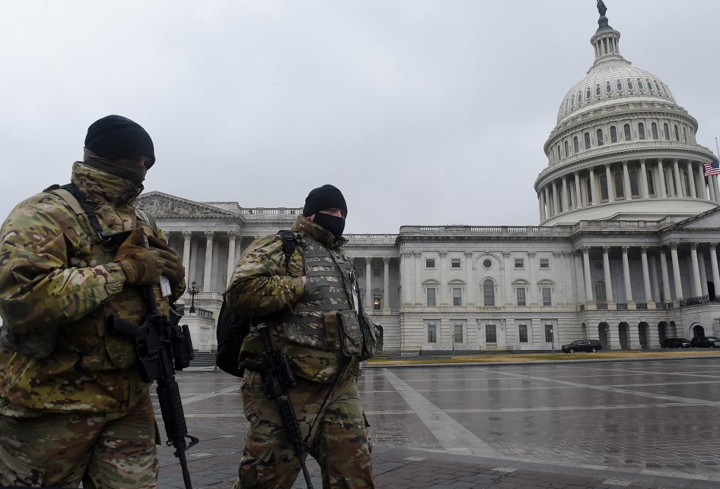 Members of the National Guard walk past the US Capitol during the second impeachment trial of former President Donald Trump in Washington, DC, February 11, 2021. (Photo by OLIVIER DOULIERY / AFP)