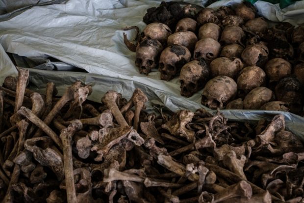 (FILES) This file photo taken on April 30, 2018 shows collected victims' bones and skulls from a newly discovered pit which was used as mass grave during 1994 Rwandan genocide and hidden under a house at the local administration office in Kabuga, the outskirts of Kigali, Rwanda. - A commission of historians will after two years work on March 26, 2021 submit to French President Emmanuel Macron a potentially explosive report scrutinising the role played by France over Rwanda's 1994 genocide, sources said. 