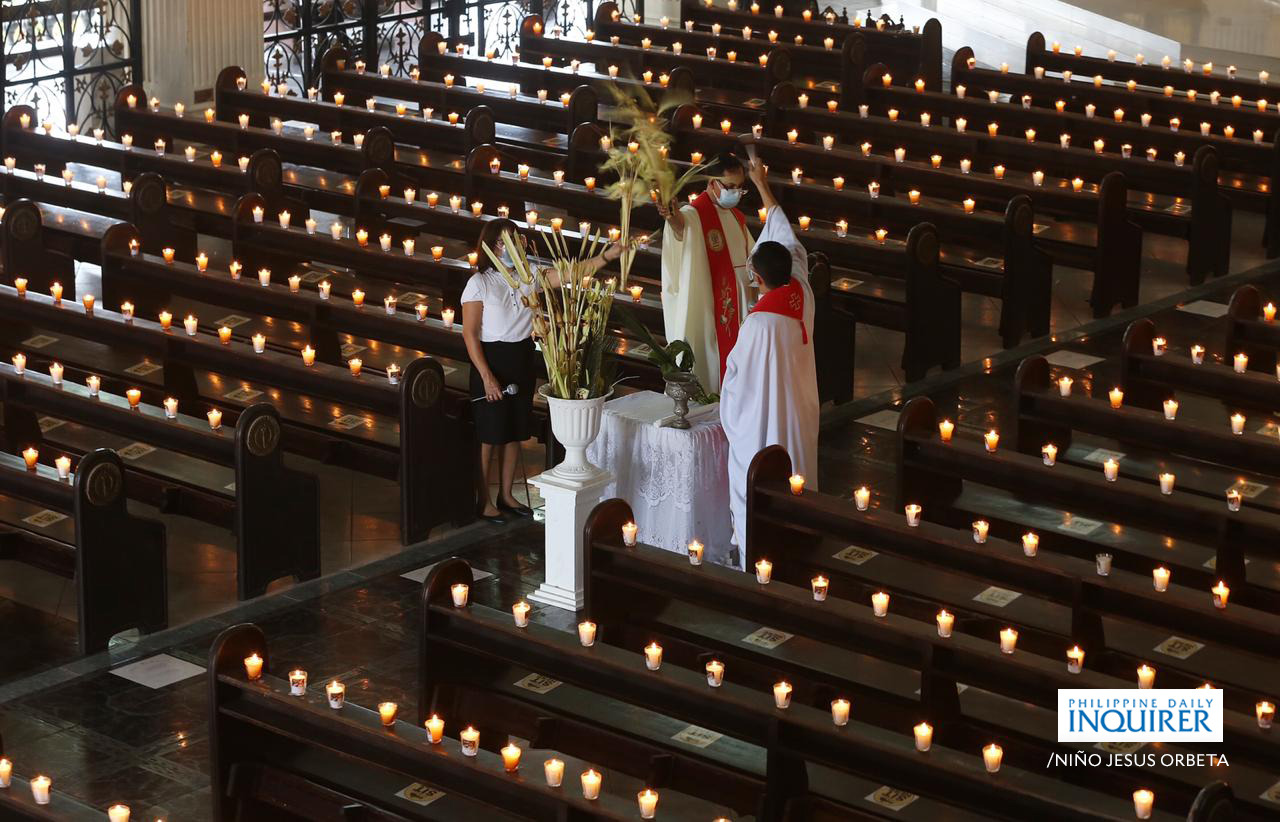 Lighted candles are placed on the empty pews of the St. Peter Parish: Shrine of Leaders, Commonwealth Avenue in Quezon City during the livestream online Palm Sunday mass. The government has declared another round of enhance community quarantine this Holy week from March 29 to April 4 amid the surge of Covid19 cases in the NCR and nearby provinces. 📷:Niño Jesus Orbeta/Philippine Daily Inquirer
