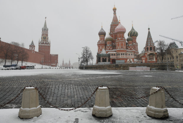 FILE PHOTO: The clock on Spasskaya tower showing the time at noon, is pictured next to Moscow’s Kremlin, and St. Basil’s Cathedral as they stand on an empty square, during the coronavirus disease (COVID-19) outbreak, in Moscow, Russia, March 31, 2020