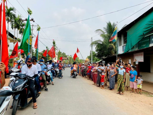 Demonstrators hold flags as they sit on motorcycles during a protest in Launglone, Dawei district, Myanmar March 26, 2021. Dawei Watch via REUTERS