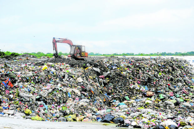 TRASH PILE In this file photo, a worker at Urdaneta City Sanitary Landfill uses a backhoe to clear a trash pile where newly delivered garbage from different towns in Pangasinan will be dumped. — Photo by WILLIE LOMIBAO 