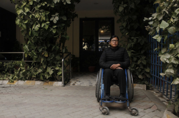 man on wheelchair working as front desk officer in Nepal