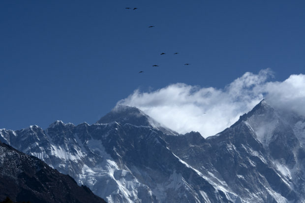 This picture taken on March, 26, 2020 shows Mount Everest (height 8,848 metres) from Namche Bazaar, the last stop before base camp in the shadow of the world's tallest mountain Everest. - The Himalayan hilltown of Khumjung should be bustling with foreign trekkers gearing up for one of Mount Everest's biggest weeks of the year, but the COVID-19 coronavirus has shut down the mountain and threatened the livelihood of the sherpas who rely on it. (Photo by PRAKASH MATHEMA / AFP) / TO GO WITH Health-virus-pandemic-Nepal-climbing,FOCUS by Paavan Mathema