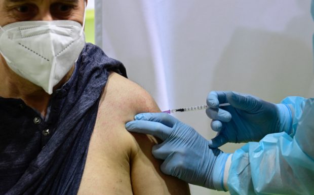 In this file photo taken on March 08, 2021 a patient receives an AstraZeneca vaccination against Covid-19 at a new vaccination centre at the former Tempelhof airport in Berlin, amid the coronavirus (Covid-19) pandemic. - Denmark, Norway and Iceland on March 11, 2021 temporarily suspended the use of AstraZeneca's Covid-19 vaccine over concerns about patients developing post-jab blood clots, as the manufacturer and Europe's medicines watchdog insisted the vaccine was safe. Denmark was first to announce its suspension, "following reports of serious cases of blood clots" among people who had received the vaccine, the country's Health Authority said in a statement. (Photo by Tobias Schwarz / various sources / AFP)