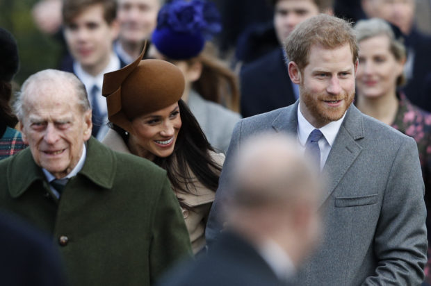In this file photo taken on December 25, 2017 (L-R) Britain's Prince Philip, Duke of Edinburgh, US actress and fiancee of Britain's Prince Harry Meghan Markle and Britain's Prince Harry (R) arrive to attend the Royal Family's traditional Christmas Day church service at St Mary Magdalene Church in Sandringham, Norfolk, eastern England. - Prince Harry and wife Meghan Markle's foundation Archewell paid tribute to Britain's Prince Philip following his death on April 9, 2021 as speculation builds about their plans to attend the funeral. (Photo by Adrian DENNIS / AFP)