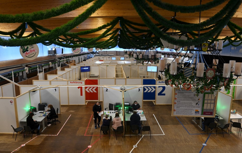 People sit at counters of a vaccination center set up in a typically Bavarian festival hall in the style of a beer tent in Rosenheim, southern Germany, on April 20, 2021, amid the novel coronavirus / COVID-19 pandemic. (Photo by Christof STACHE / AFP) germany covid-19 vaccination