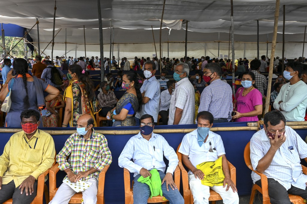 People wait in a queue to receive the Covid-19 coronavirus vaccine at a vaccination centre in Mumbai on April 22, 2021. (Photo by Punit PARANJPE / AFP)