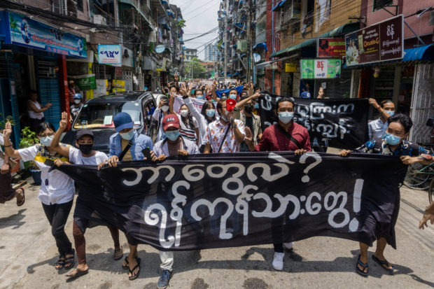 Protesters hold a banner that reads, "Who are we? We are Yangon resident" during a demonstration against the military coup 