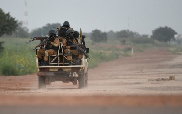 In this file photograph taken on September 29, 2015, Burkinabe gendarmes patrol near the Presidential Security Regiment (RSP) military barracks in Ouagadougou. - Burkina Faso security forces launched a massive manhunt on April 27, 2021, after the abduction of three Westerners along with a Burkinabe national, as a top security source warned at least two of them may have been killed. The group was abducted after an attack on an anti-poaching patrol in the landlocked West African nation, security and diplomatic sources said. A Spanish foreign ministry source told AFP in Madrid that two Spanish nationals were missing. A security source in Burkina Faso said an Irish man was also among the group. 