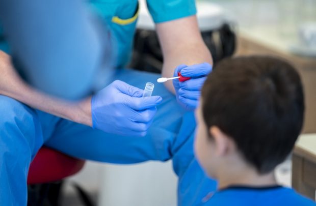 A medical worker prepares a newly developed, lollipop-shaped Covid-19 test prior to the testing of pre-schoolers at the 'City of Vienna Kindergarten' in Vienna, Austria on April 28, 2021. - The new lollipop test, a more sensible alternative to other testing options, is being rolled out in some of Austria's kindergartens as an alternative for toddlers who don't take well to throat or nose swabs a spokesperson for the regional government told AFP