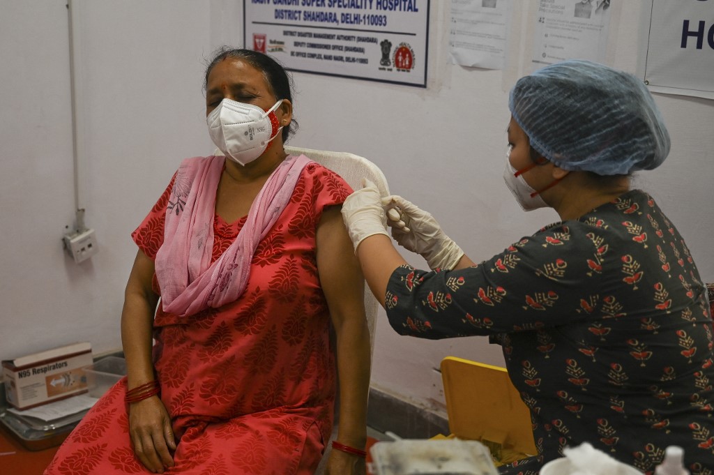 A medical worker inoculates a woman with a dose of the Covishield Covid-19 coronavirus vaccine at Rajiv Gandhi Super Speciality ahospital in New Delhi on April 29, 2021. (Photo by Prakash SINGH / AFP)