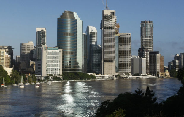 The Brisbane River is seen flowing past the skyline of central Brisbane