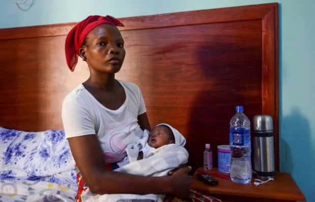 Fato Abdula Ali who gave birth while fleeing an attack on the town of Palma, sits with her child at a hotel in Pemba
