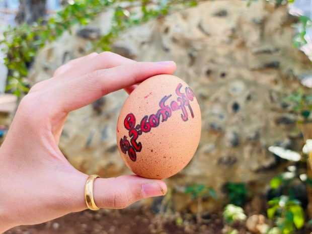 A person shows a painted Easter egg with a sign reading "Spring Revolution" following the protests against the military coup, in Mandalay, Myanmar April 3, 2021 in this picture obtained by Reuters from social media.