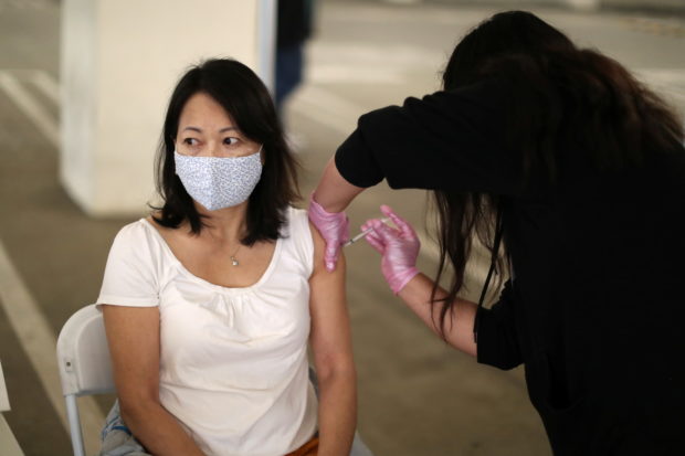 Chauphuong Ly Dinh, 50, is given a coronavirus disease (COVID-19) vaccination, in Los Angeles, California, U.S., April 12, 2021. REUTERS/Lucy Nicholson