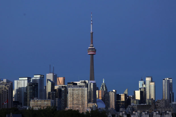 The CN Tower stands at dusk above office buildings and condominiums in the downtown core of Toronto, Ontario, Canada September 20, 2020. REUTERS/Chris Helgren