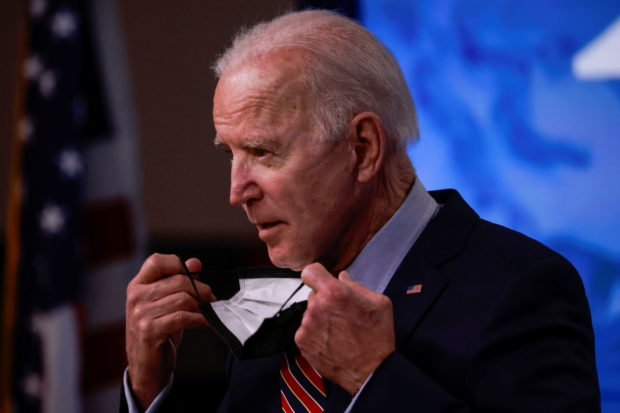 v\U.S. President Joe Biden removes his face mask to speak about the status of coronavirus disease (COVID-19) vaccinations and his administration's ongoing COVID-19 pandemic response in the Eisenhower Executive Office Building at the White House in Washington, U.S., April 21, 2021.