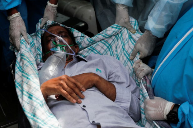 A patient suffering from the coronavirus disease (COVID-19) is evacuated from a hospital after it caught fire in Virar, on the outskirts of Mumbai, India, April 23, 2021. REUTERS/Francis Mascarenhas