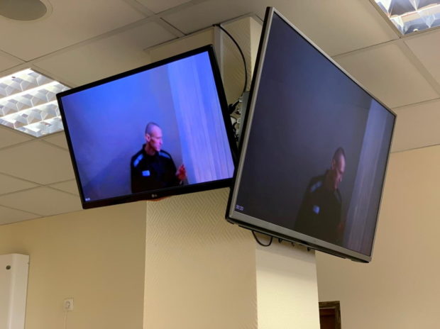 Russian opposition leader Alexei Navalny is seen on screens via video link before a hearing to consider an appeal against an earlier court decision that found him guilty of slandering a Russian World War Two veteran, in Moscow, Russia April 29, 2021
