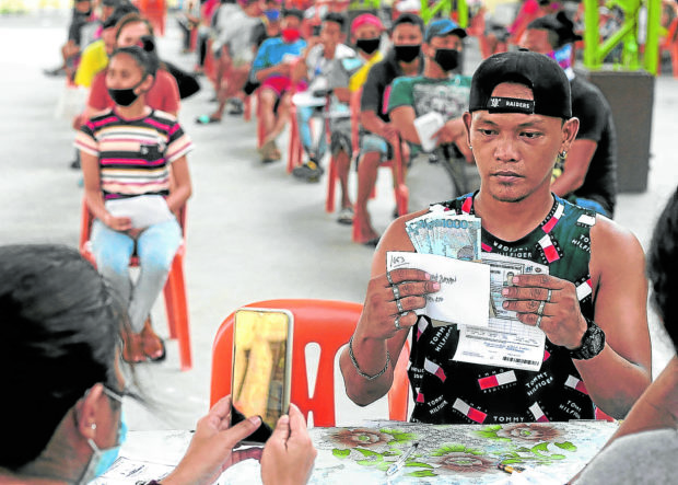 ‘AYUDA’ LINE Residents queue to receive their cash aid under the government’s social amelioration program. —RICHARD A. REYES