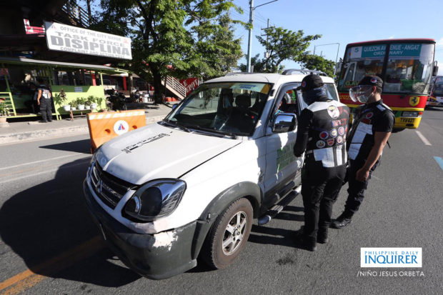 Members of Inter-Agency Council for Traffic-Special Operations Unit apprehend public utility vehicles for violating health protocols and the 50% maximum seating restrictions implemented during Enhance Community Quarantine in National Capital Region bubble plus along Commonwealth Avenue in Quezon City on Sunday, April 11
