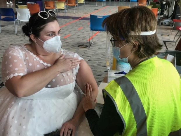 bride wears gown to covid vaccination