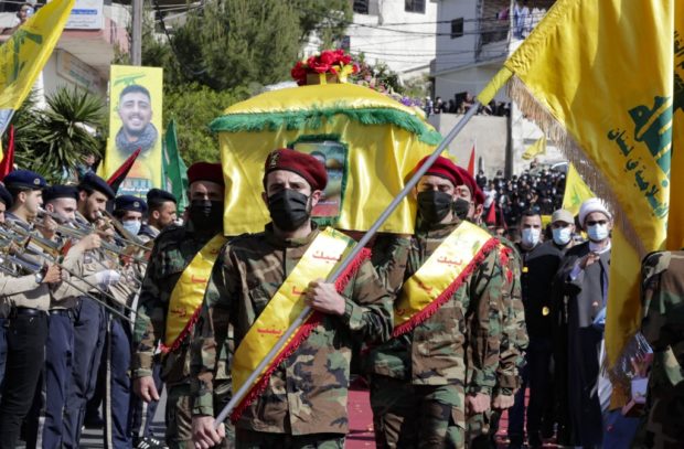 In this file photo taken on May 15, 2021 Members of the Iran-backed Hezbollah movement, carry the coffin of Mohamad Kassem Tahan, a fellow member killed a day earlier by Israeli shelling on the frontier with Lebanon during a protest against the latest assault on the Gaza Strip, at his funeral in the southern Lebanese village of Adloun. - Israel's deadly Gaza offensive has many eyes trained on the Lebanese border for a Hezbollah reaction but observers argue the Iran-backed movement is unlikely to risk an all-out conflict. Hezbollah and the Palestinian Hamas, both designated as terrorist groups by Israel and much of the West, have mended fences after ending up on opposing sides of the Syrian war a decade ago. 
