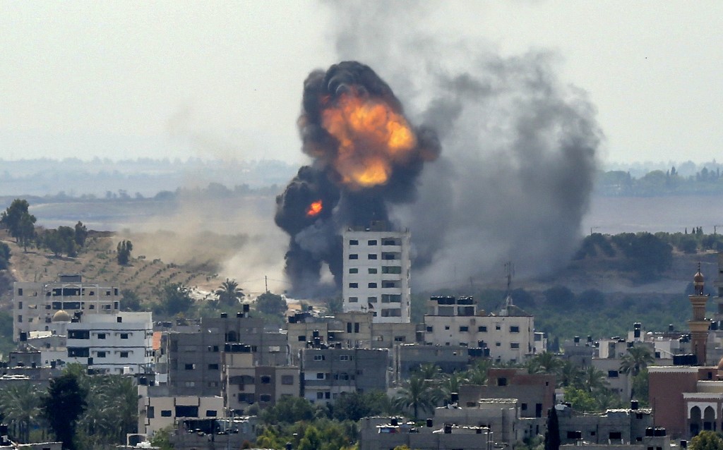 A ball of fire erupts from a building in Gaza City's Rimal residential district on May 20, 2021, during Israeli bombardment on the Hamas-controlled enclave. - Israel and the Palestinians are mired in their worst conflict in years as Israel pounds the Gaza Strip with air strikes and artillery, while Hamas militants fire rockets into the Jewish state. (Photo by BASHAR TALEB / AFP)