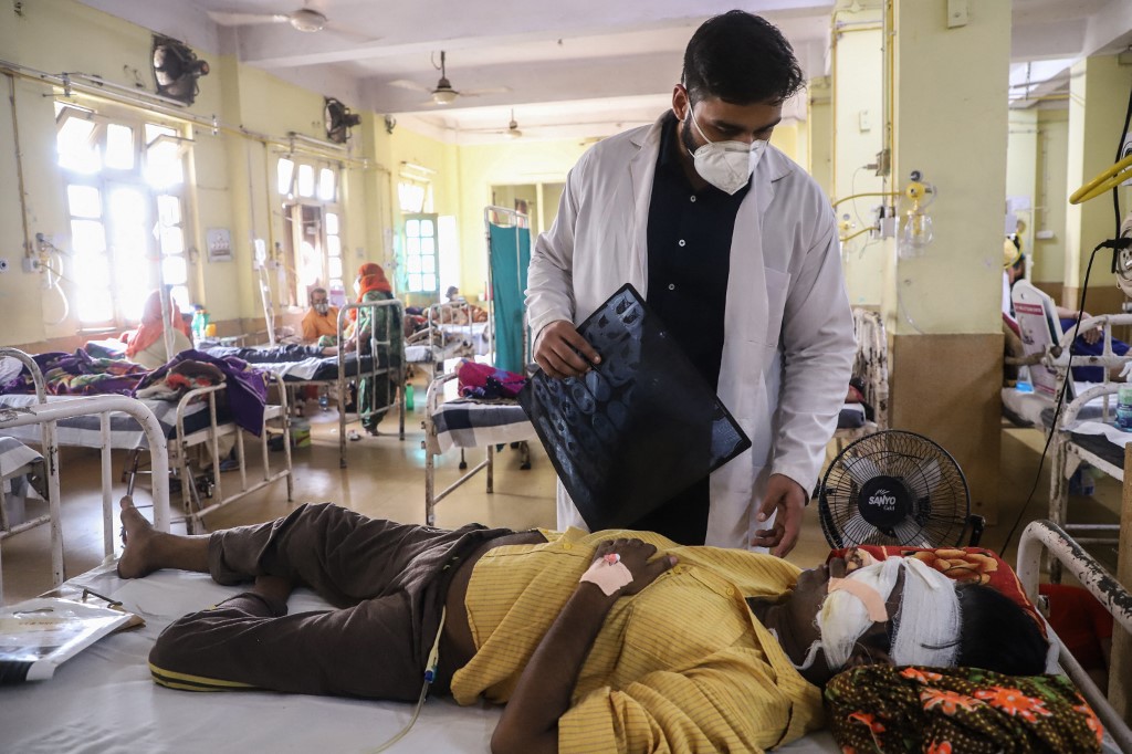 A doctor assists a Covid-19 coronavirus patient with Black Fungus, a deadly and rare fungal infection, as he receives treatments at the NSCB hospital in Jabalpur, on May 20, 2021. (Photo by Uma Shankar MISHRA / AFP)