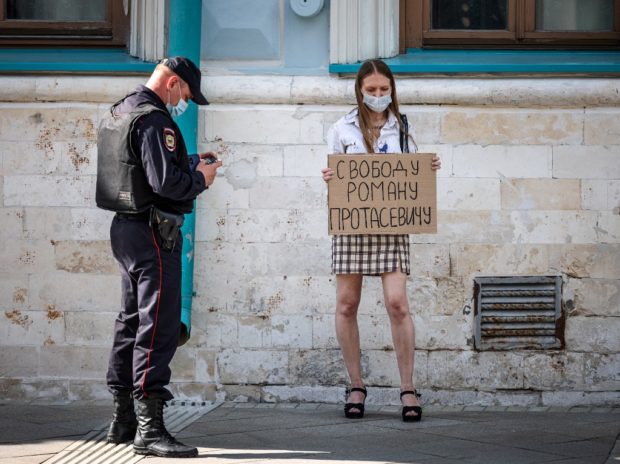 A woman holds a placard which reads 'Freedom for Roman Protasevitch' as she attends a single-person protest of solidarity with the jailed Belarusian opposition journalist in front of the Belarusian embassy in central Moscow on May 25, 2021. - Belarus's opposition called on May 25 for more pressure on the longtime Belarusian leader as Europe moved to cut air links with the country over the extraordinary diversion of an airliner and arrest of a dissident on board. The forced landing of the Ryanair flight from Athens to Vilnius on May 23 and arrest of opposition journalist sparked an international outcry.