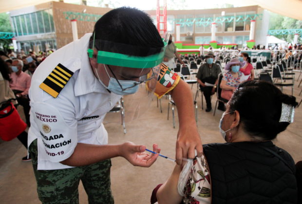 A woman receives a dose of the AstraZeneca coronavirus disease (COVID-19) vaccine, during a mass vaccination program in Monterrey, Mexico April 12, 2021