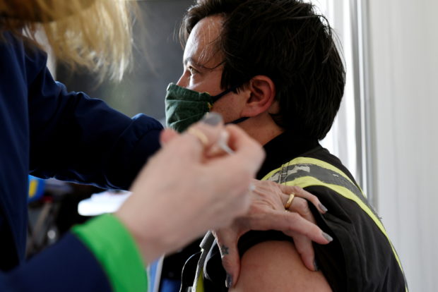 Manitoba-based truckers, transporting goods to and from the United States, get vaccinated against coronavirus disease (COVID-19) as part of a deal between the Canadian province and the state of North Dakota, at a rest stop near Drayton, North Dakota, U.S. April 22, 2021. REUTERS/Dan Koeck/File Photo