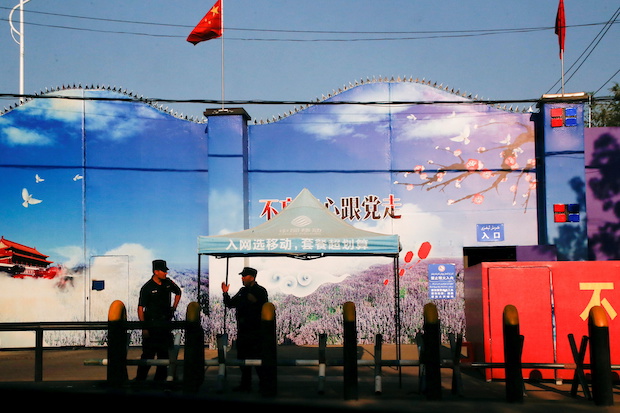 Security guards stand at the gates of what is officially known as a vocational skills education centre in Huocheng County