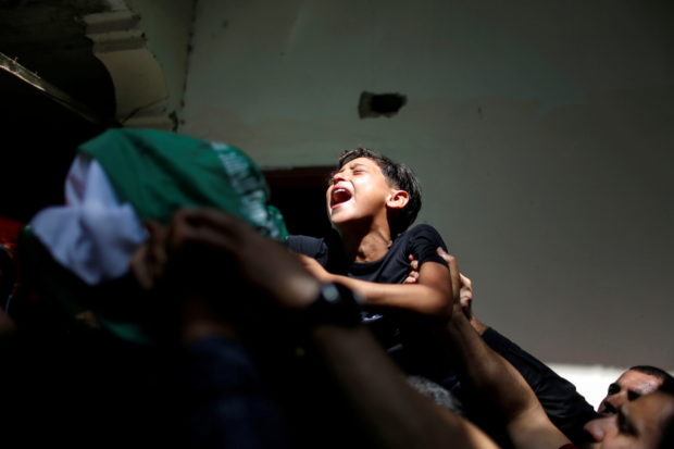 The brother of Palestinian man Ahmed Al-Shenbari, who was killed amid a flare-up of Israeli-Palestinian violence, reacts as mourners carry his body during his funeral in the northern Gaza Strip May 11, 2021
