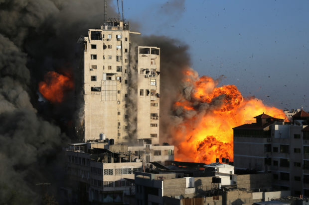 Smoke and flames rise from a tower building as it is destroyed by Israeli air strikes amid a flare-up of Israeli-Palestinian violence, in Gaza City May 12, 2021. REUTERS/Ibraheem Abu Mustafa