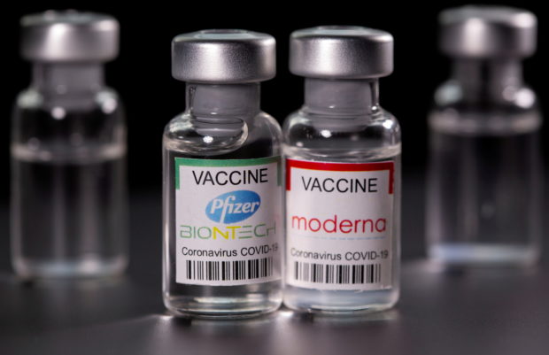 Vials with Pfizer-BioNTech and Moderna coronavirus disease (COVID-19) vaccine labels are seen in this illustration picture taken March 19, 2021