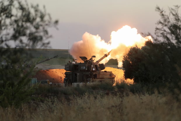 Israeli soldiers work in an artillery unit as it fires near the border between Israel and the Gaza strip, on the Israeli side May 19, 2021 REUTERS/ Ammar Awad