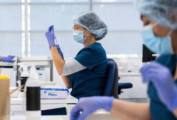 Staff members prepare vaccines at a New South Wales coronavirus disease (COVID-19) mass vaccination hub as it opens at Sydney Olympic Park in Sydney, Australia, May 10, 2021