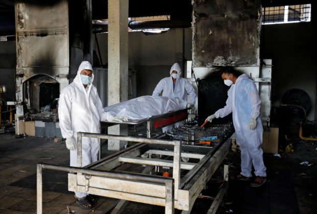 Volunteers from the Khan Trust prepare to cremate the body of a person who died from the coronavirus disease (COVID-19), at the Kurukshetra Crematorium in Surat, India, May 11, 2021.