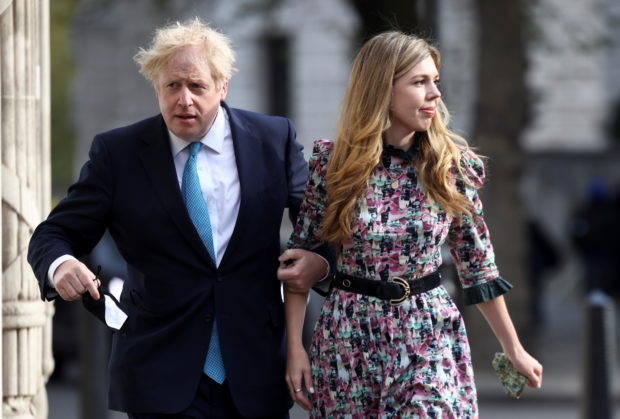 Prime Minister Boris Johnson and partner Carrie Symonds walk to Westminster polling station to vote, in London, Britain May 6, 2021. REUTERS/Henry Nicholls