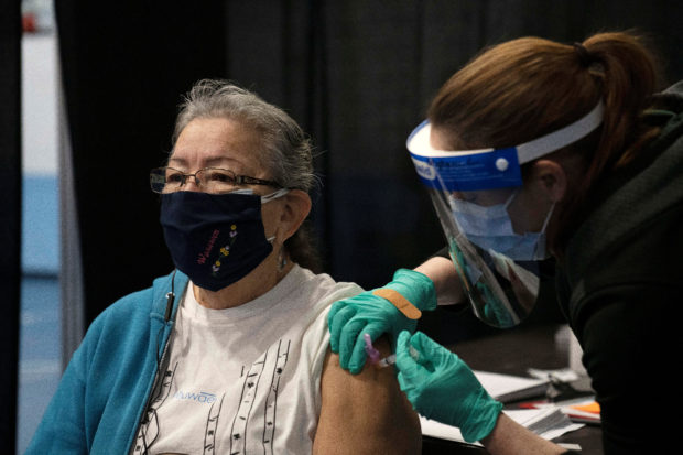 Myrna Warrington, 72, receives the coronavirus disease (COVID-19) vaccination from nurse Stephanie Ciancio at Menominee Indian High School in Menominee county, Wisconsin, U.S., January 28, 2021. REUTERS/Lauren Justice/File Photo