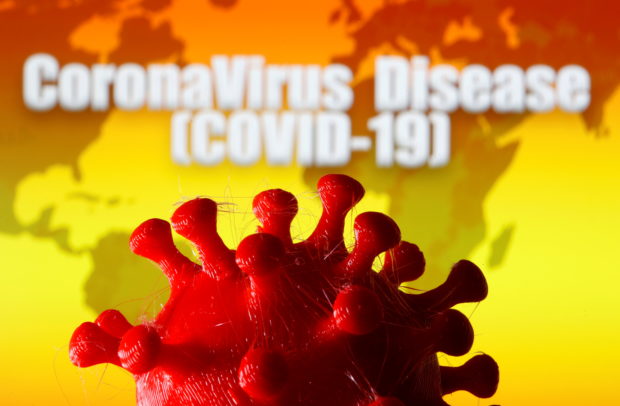 A 3D-printed coronavirus model is seen in front of a world map and the words "CoronaVirus Disease (Covid-19)" on display in this illustration taken March 25, 2020. REUTERS/Dado Ruvic/Illustration/File Photo