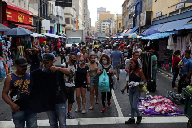 People walk at the 25 de Marco popular shopping street before Christmas, amid the coronavirus disease (COVID-19) outbreak, in downtown Sao Paulo, Brazil December 21, 2020