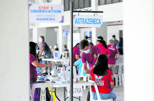 ANOTHER JAB Hospital workers and personnel of the Philippine National Police receive their AstraZeneca COVID-19 shots at a vaccination center in Marikina City on March 24.