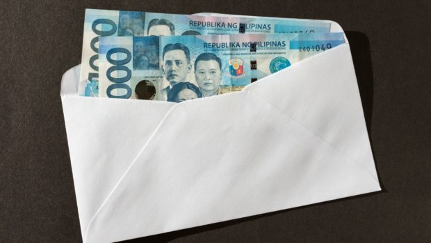 Envelope with two 1,000-peso bills. STORY: P2,000 monthly subsidy for disabled minors pushed