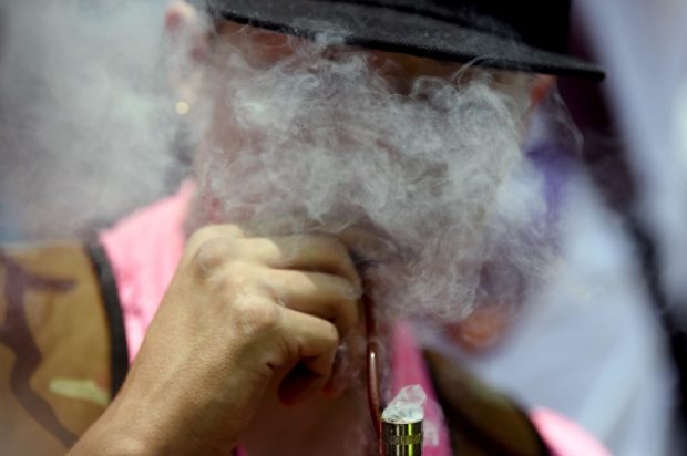 A man smokes a pipe during a demonstration demanding the legalization of marijuana for recreational use, in front of the Senate in Mexico City on April 20, 2021