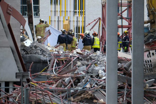 Rescue workers inspect the rubble of a collapsed building, a day after a school construction site partially collapsed in the Belgian city of Antwerp on June 19, 2021. - Three construction workers were confirmed dead and two still missing. (Photo by NICOLAS MAETERLINCK / BELGA / AFP) / Belgium OUT